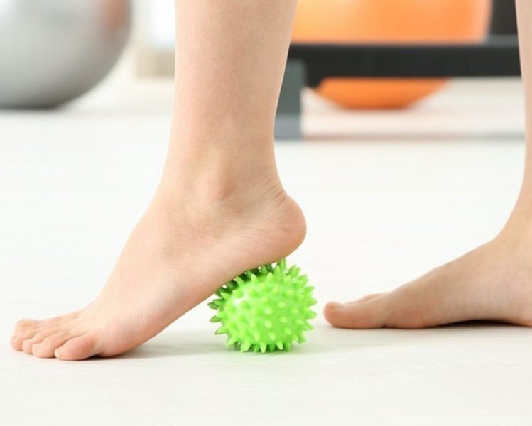 pie descalzo jugando con pelota para hacer ejercicios de musculatura