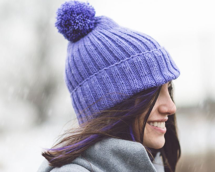 mujer con gorro morado para evitar el frío